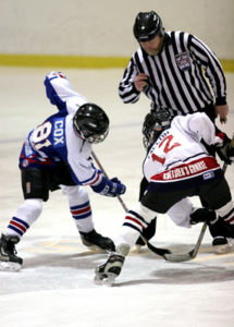 Two young boys participate in a puck drop at a hockey rink in Chicago, IL